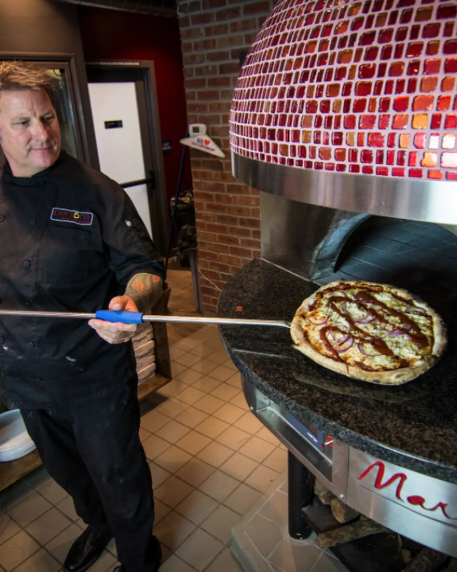 Il pizzaiolo infila la pala nel forno
